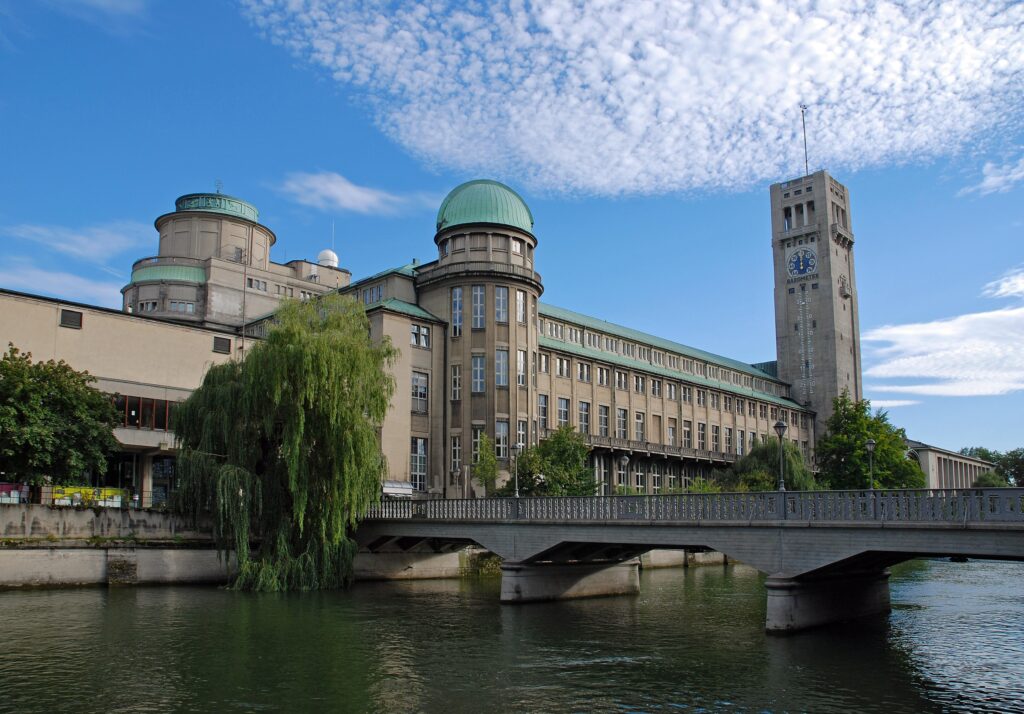 Das Deutsche Museum in München ist eines der traditionsreichsten und größten Wissenschafts- und Technikmuseen der Welt. Vor mehr als 100 Jahren gegründet, beherbergt das Deutsche Museum heute eine der bedeutendsten naturwissenschaftlich-technischen Sammlungen. An den drei Standorten auf der Münchner Museumsinsel, dem Verkehrszentrum am Bavariapark und der Flugwerft Schleißheim laden Demonstrationen, Experimente und Medienstationen zum Mitmachen und Ausprobieren ein. Die hier versammelten Meisterwerke bringen uns zum Staunen und fordern den Geist heraus: Von den ersten Computern und Flugzeugen, dem ersten Benzinauto und riesigen Schiffen bis hin zu den ersten Mikroskopen. Die thematische Bandbreite ist riesig: Von der Astronomie bis zur Meeresforschung, von der Nanotechnologie bis zum Bergwerk, von Uhren und Musikinstrumenten bis hin zur Pharmazie. Das Deutsche Museum versteht sich als Ort des aktiven Lernens, an dem Kinder und Erwachsene ihre Neugier stillen können: hören und sehen, anfassen, ausprobieren und erleben! The Deutsche Museum (German Museum) in Munich is one of the largest and most traditional science and technology museums in the world. Children and adults can discover a lot on seven levels! Founded over 100 years ago, the Deutsche Museum now houses one of the most important natural history collections in the world. At the main building on Münchner Museumsinsel (Munich museum island), at the Verkehrszentrum transport museum next to Bavariapark and at Flugwerft Schleissheim aviation museum, visitors are encouraged to get involved and have a hands-on experience with demonstrations, experiments and media stations. The master pieces on show are sure to have you in awe and awaken your spirit for discovery: From early computers and aeroplanes, the first-ever petrol car and giant ships, to the world’s first microscopes. The subjects covered by the museum are diverse: From astronomy to marine biology, nanotechnology to mining, clocks and musical instruments all the way to pharmaceuticals. The Deutsche Museum classes itself as a home of active learning, giving children and adults the chance to quench their thirst for knowledge by hearing, seeing, touching, testing and experiencing!